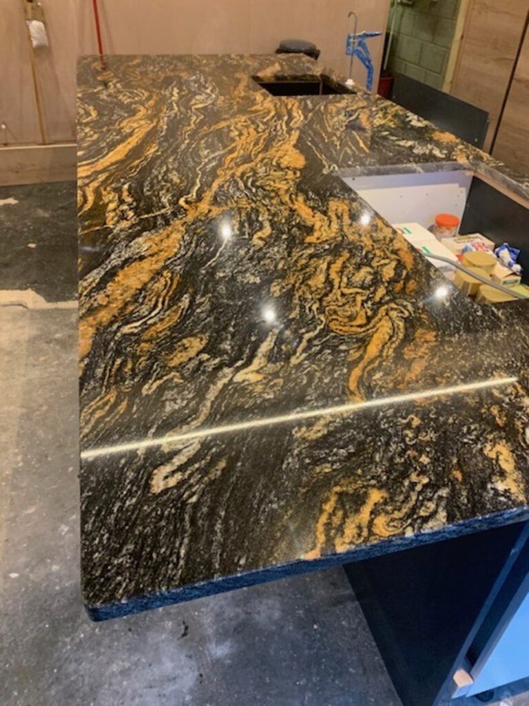 Granite Cosmic Gold black with big gold veins running through the slab installed in Manchester Astley