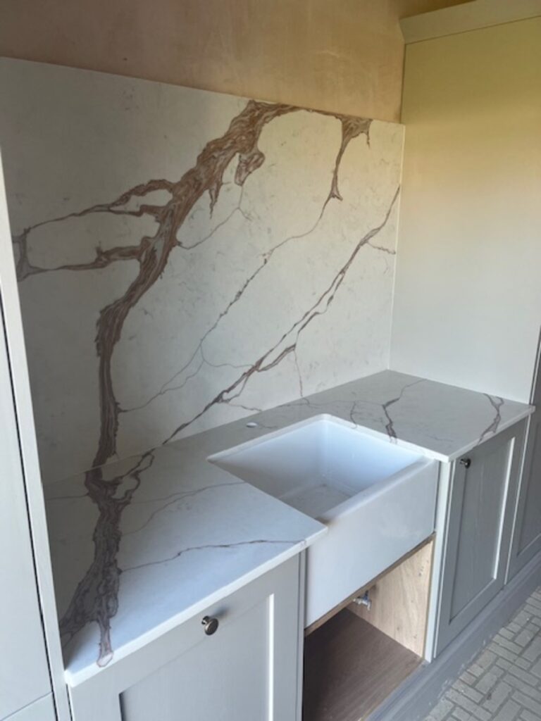 Nile Calacatta Oro with a belfast sink cut out and Hob splash back installed in Prenton Wirral