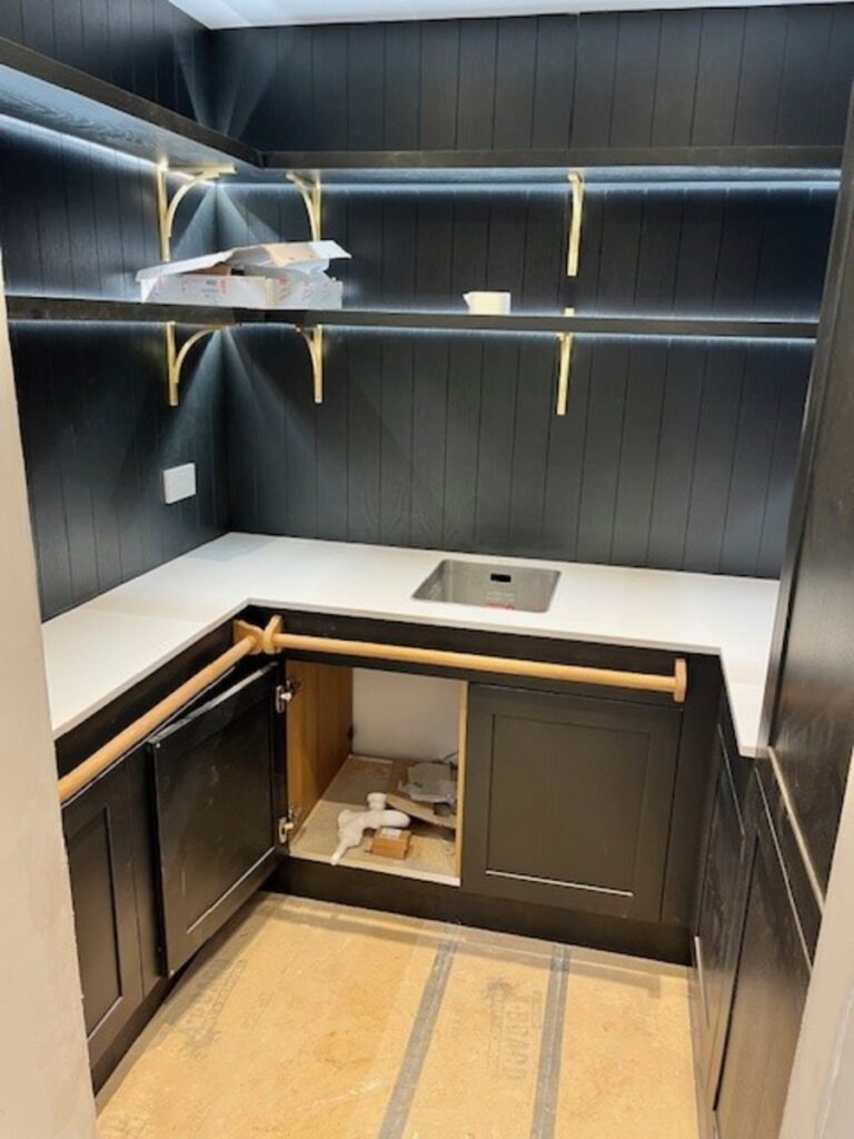 20 mm Super white quartz on a dark blue cladded kitchen with brass handles